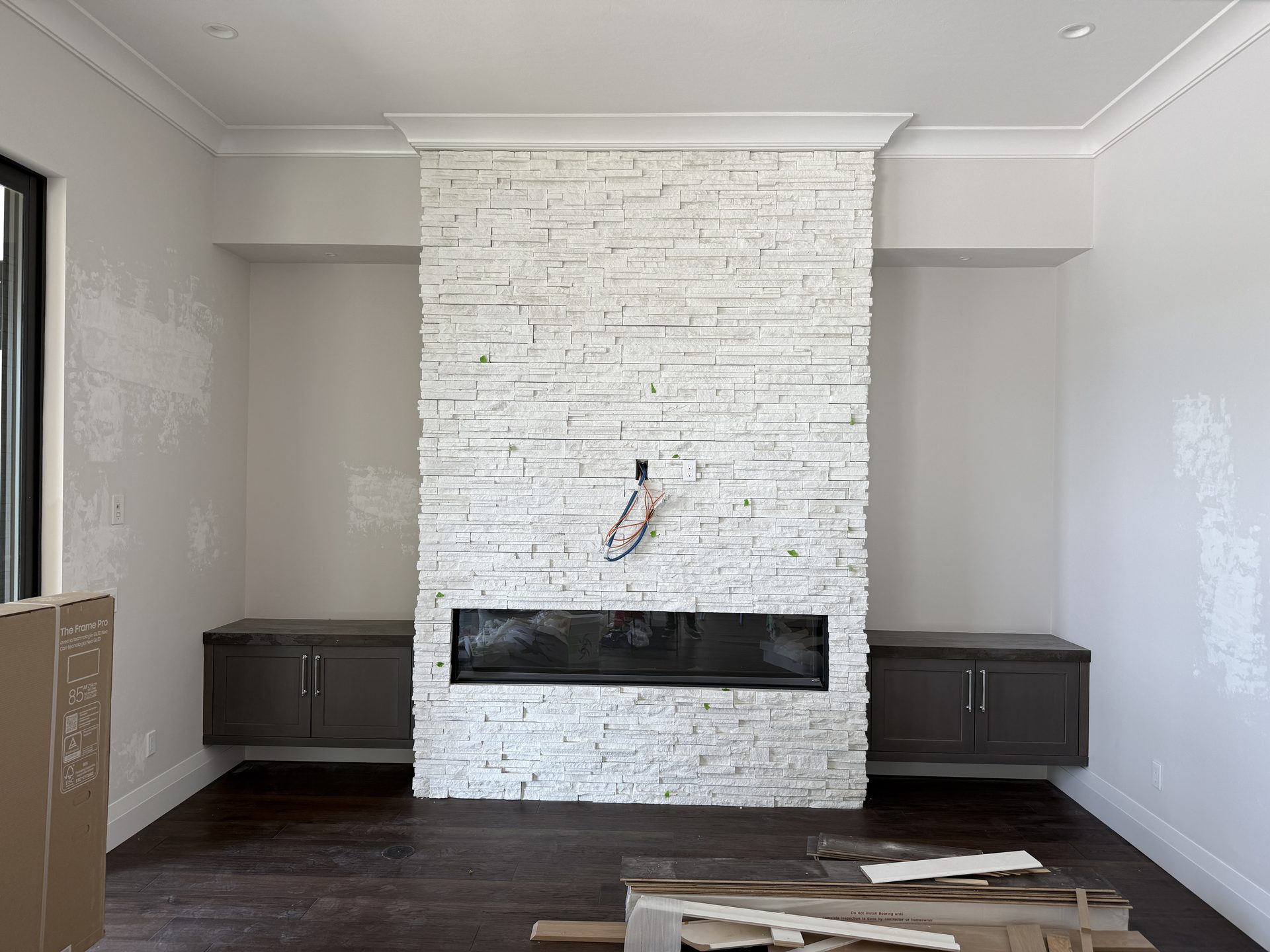 Empty stacked-stone fireplace before The Frame — Shadow Wood